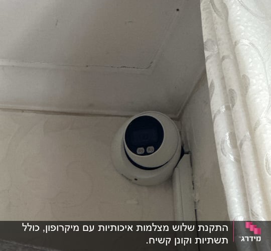 מצלמת אבטחה מותקנת בפינת תקרה ליד וילון